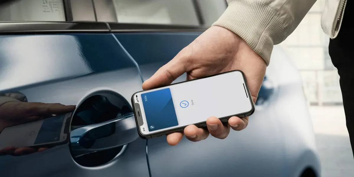iPhonea pidetään lähellä auton ovea Apple Walletin digitaalisella autonavaintoiminnolla