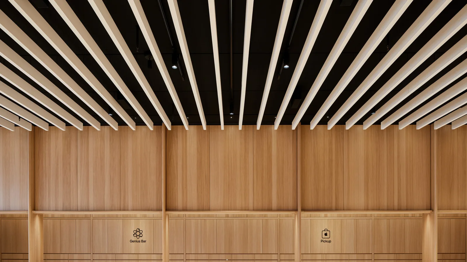 Interior of an Apple retail store showing product tables and a service counter